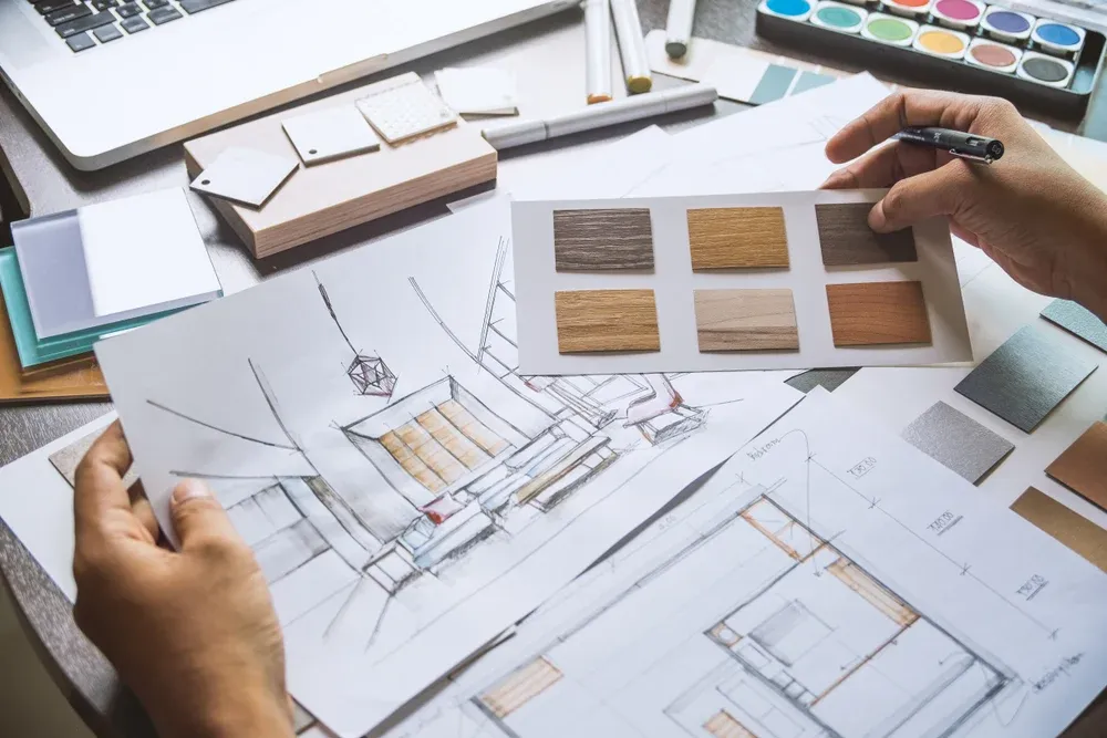Design sketches, material samples, and plans on a desk